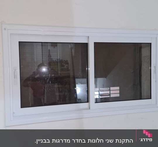 חלון עם תריסים סגורים ומסגרת לבנה